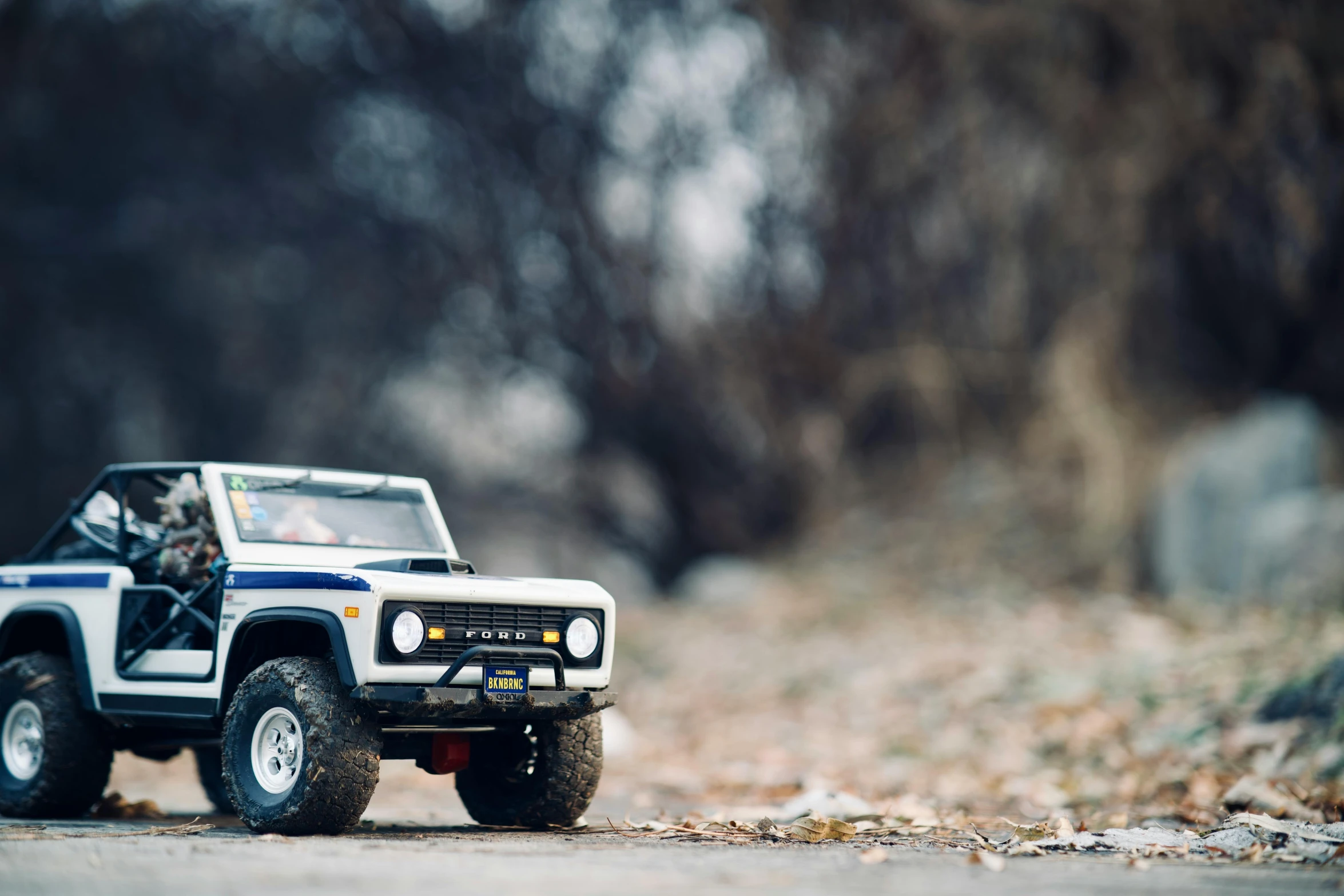 a toy jeep driving down a dirt road, unsplash, photorealism, detailed medium format photo, with cool headlights, old school fpr, wide body