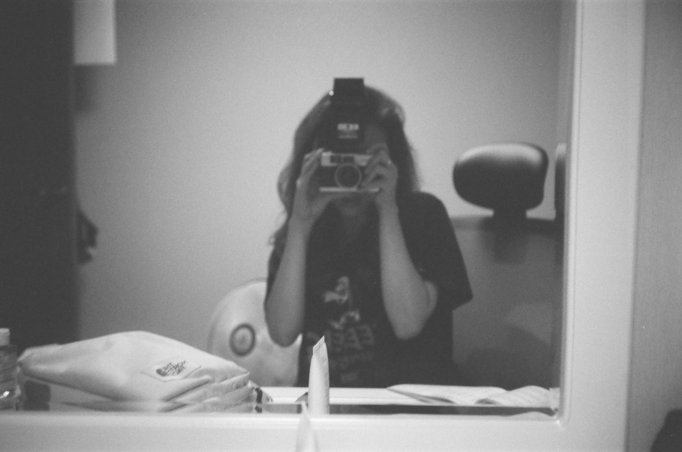 a woman taking a picture of herself in a mirror, a black and white photo, tumblr, cynthwave, desaturated!!, photocopy, profile image