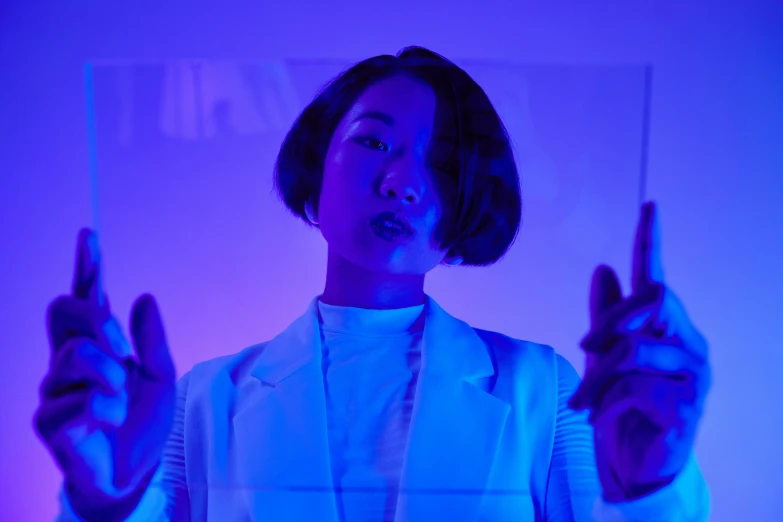 a woman in a lab coat holding a pair of scissors, an album cover, inspired by Zhu Da, unsplash, neo-dada, blue and purle lighting, ryoji, pose 4 of 1 6, blue room