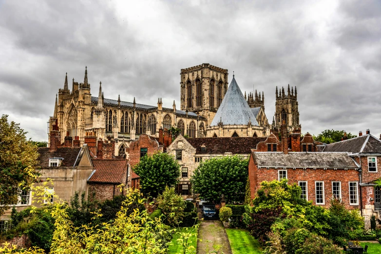 a large cathedral towering over a lush green field, by IAN SPRIGGS, pexels contest winner, hull, medieval tumbledown houses, square, a quaint