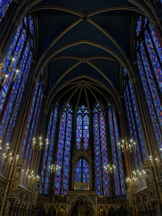 the interior of a cathedral with stained glass windows, a photo, by artist, gothic art, ultramarine blue and gold, and, colorful and dark, wrought iron architecture