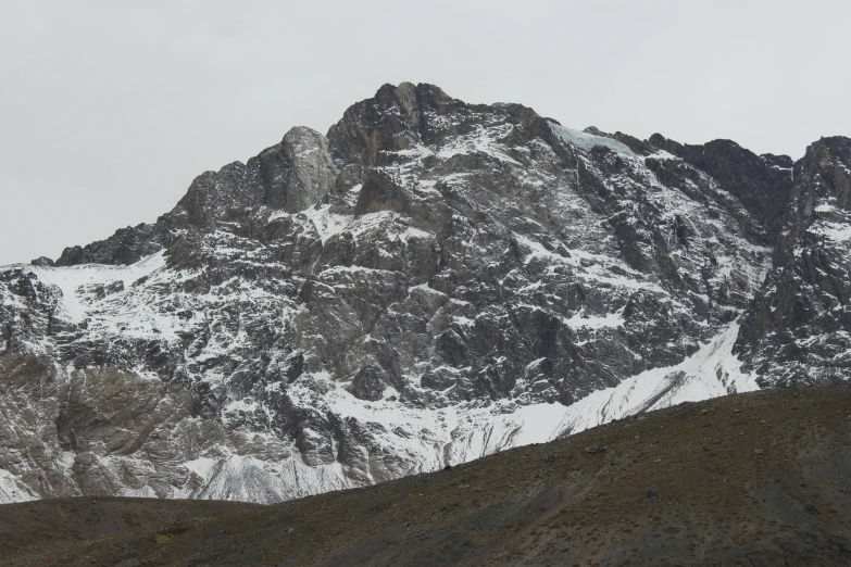 a large mountain covered in snow on a cloudy day, hurufiyya, nature photo, andes, high detail photo, 3/4 front view