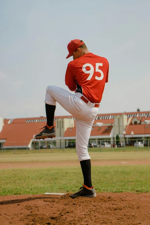 a baseball player pitching a ball on top of a field, pexels contest winner, figuration libre, fully body pose, style of vogelsang, back and standing, red sport clothing