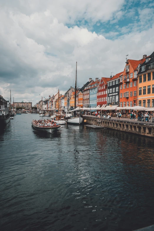 a river filled with lots of boats next to tall buildings, a photo, by Jesper Knudsen, pexels contest winner, renaissance, denmark, color image, 🚿🗝📝