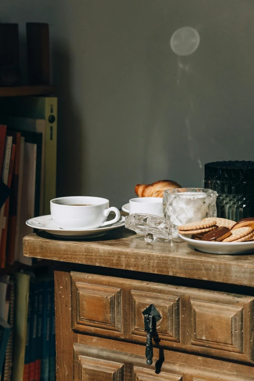 a wooden table topped with plates of food, a still life, by Jan Tengnagel, pexels contest winner, renaissance, two cups of coffee, small library, soft morning light, gif