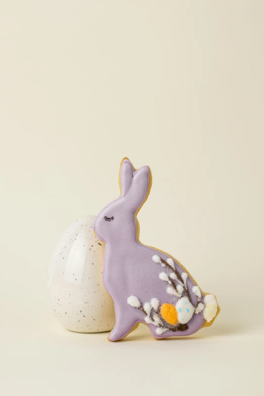 a cookie shaped like a bunny sitting next to an egg, a pastel, lilacs, high resolution product photo, front shot, gilt