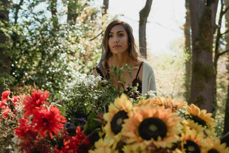 a woman standing in front of a bunch of flowers, the fall season, profile image, behind the scenes photo, asher duran