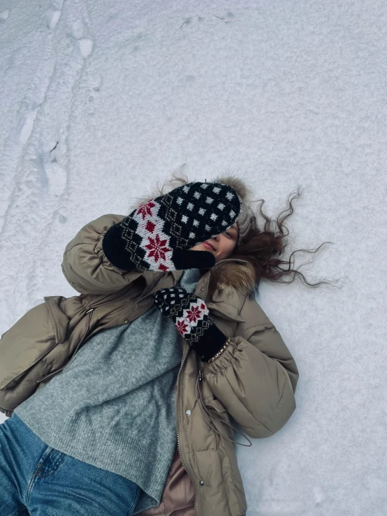 a woman laying in the snow on a snowboard, by Lucia Peka, pexels contest winner, symbolism, holding his hands up to his face, profile image, iphone photo, ☁🌪🌙👩🏾