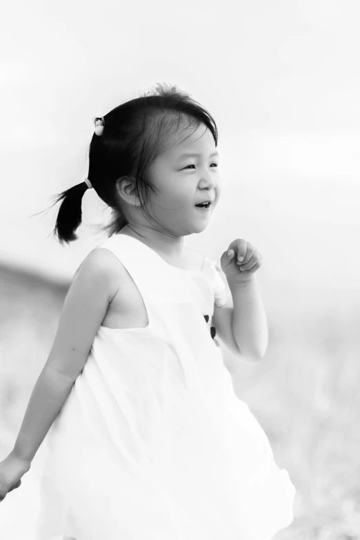 a black and white photo of a little girl, inspired by Tang Yifen, pexels contest winner, wearing a cute white dress, sun-hyuk kim, extremely happy, song nan li