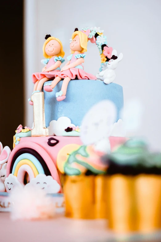 a cake sitting on top of a table next to cupcakes, by Julia Pishtar, cute girls, close up angle, softplay, thumbnail