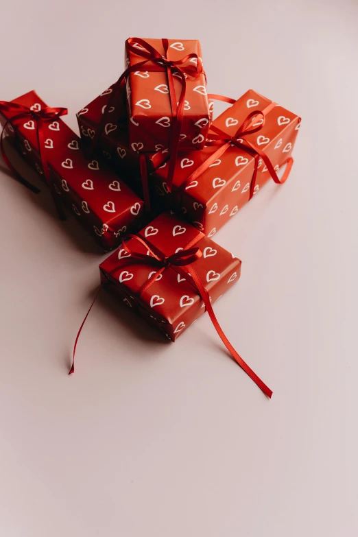 a pile of wrapped presents sitting on top of a table, by Jessie Algie, pexels, red hearts, screensaver, all red, box