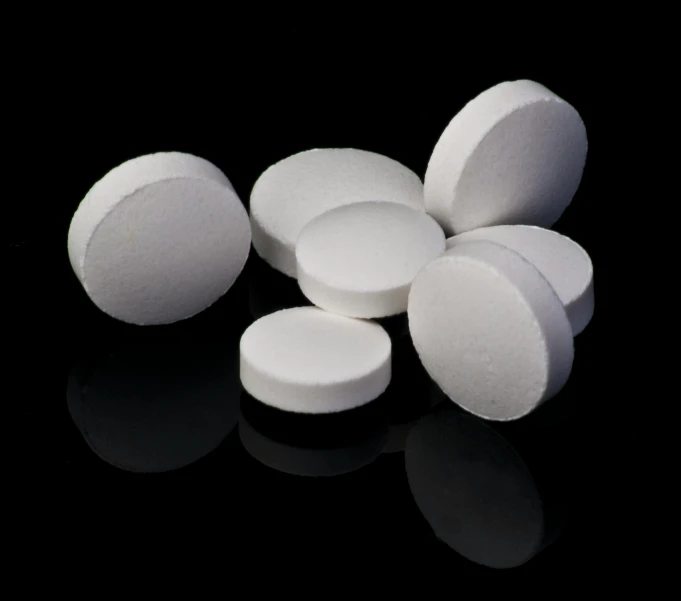 a pile of white pills sitting on top of a black surface, sleek round shapes, lake, product image, biroremediation
