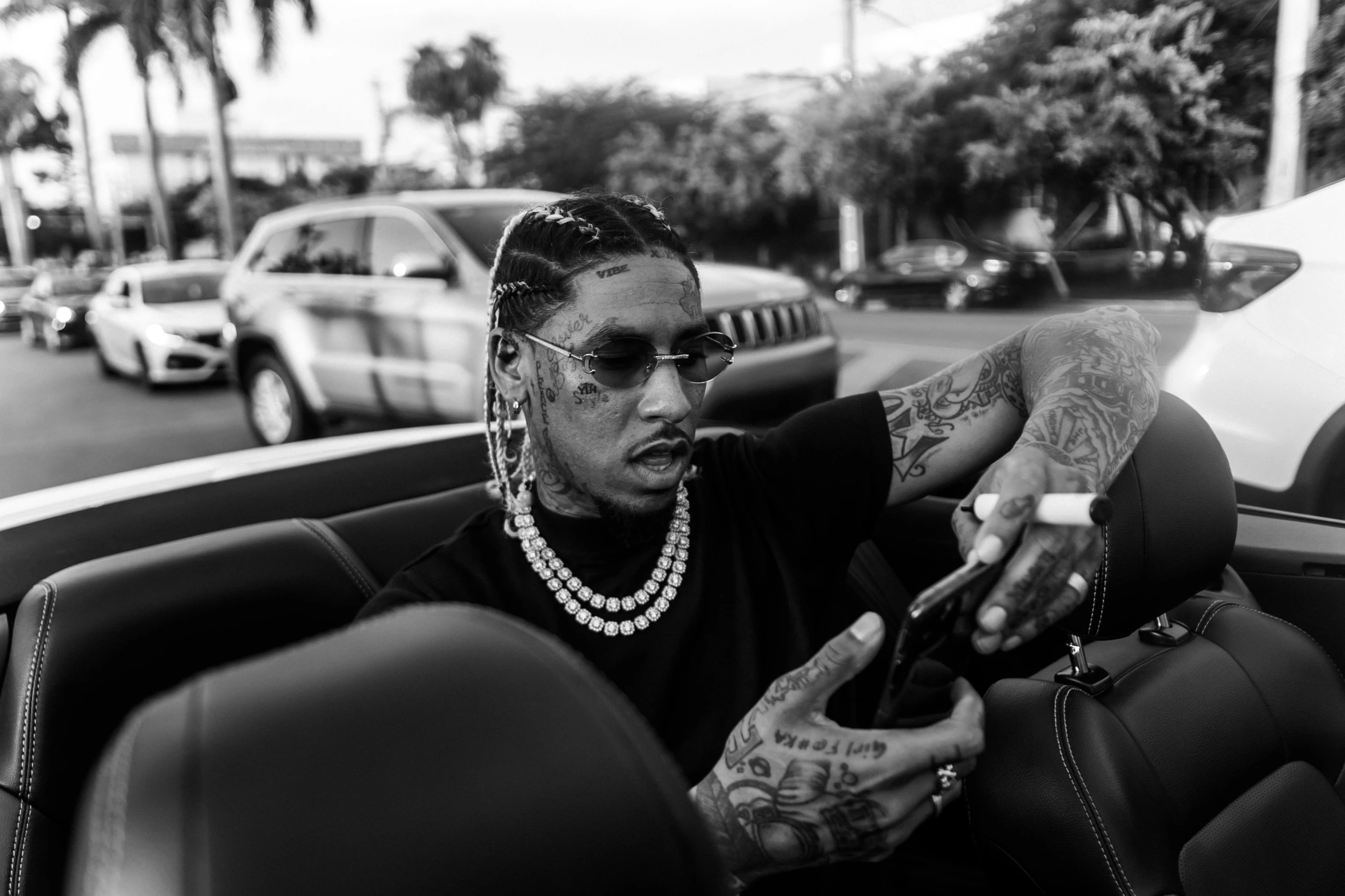 a man sitting in the driver's seat of a car, a black and white photo, trending on pexels, wiz khalifa, cornrows, gucci poster, 12