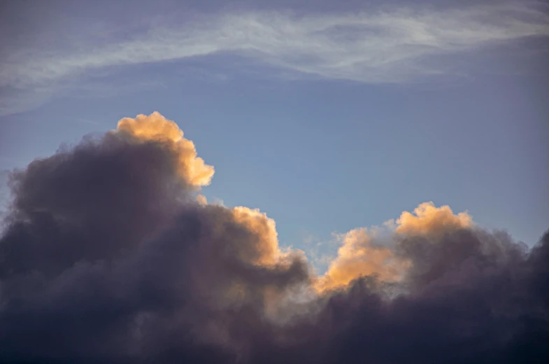 a plane flying through a cloudy blue sky, by Neil Blevins, unsplash, romanticism, violet and yellow sunset, giant cumulonimbus cloud, colour photograph, evening light