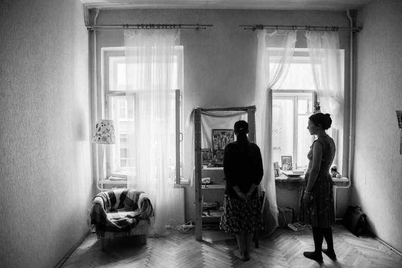 a couple of women standing next to each other in a room, a black and white photo, by andrei riabovitchev, socialist realism, apartment of an art student, parents watching, gettyimages, lonely family