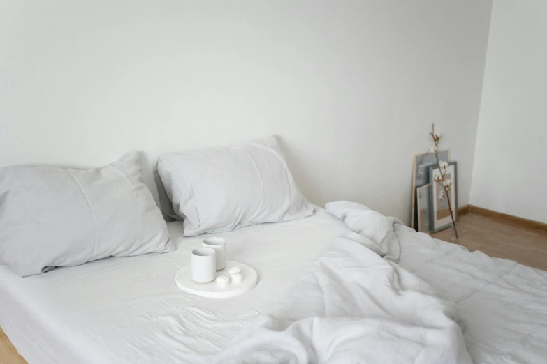 a white bed with a cup of coffee on it, by Simon Gaon, trending on unsplash, minimalism, light grey mist, ignant, multiple layers, modeled