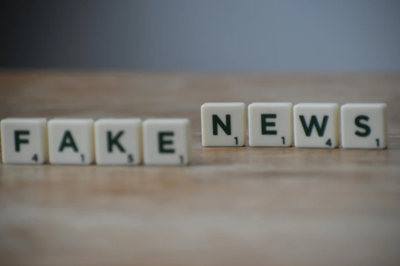 fake news cubes sitting on top of a wooden table, a picture, by Emma Andijewska, trending on unsplash, new objectivity, on grey background, awakening, unedited, navy