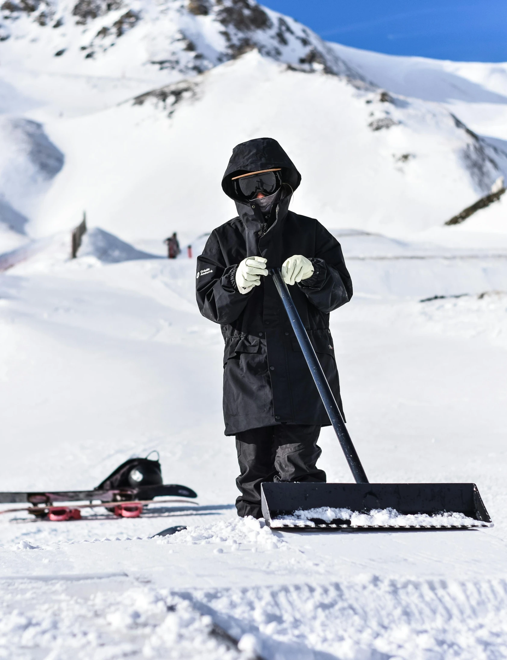 a man standing on top of a snow covered slope, tech robes, sweeping, balaclava, black