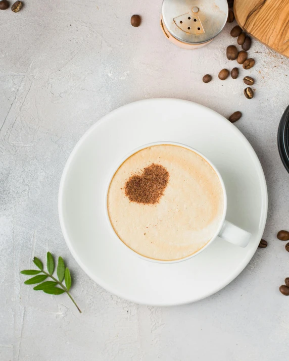 a cup of coffee sitting on top of a white plate, heart - shaped face, product image, high quality product image”