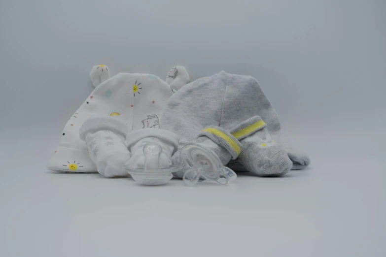 a couple of stuffed animals laying next to each other, on a gray background, incubator medpods, various sizes, white