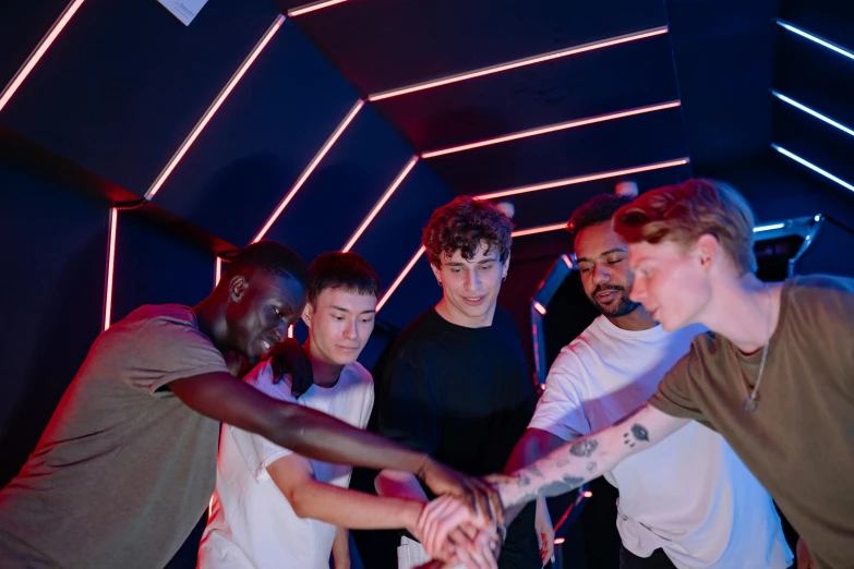 a group of people putting their hands together, an album cover, interactive art, standing in a starbase bar, colour led, cute boys, round-cropped