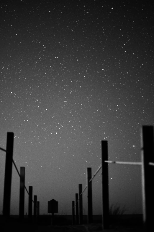 a black and white photo of the night sky, a black and white photo, unsplash, postminimalism, fence, starry sky 8 k, **cinematic, (fantasy)