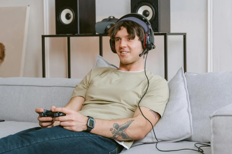 a man sitting on a couch with headphones on, pexels, hyperrealism, gaming room, nathan fielder, avatar image, instagram post