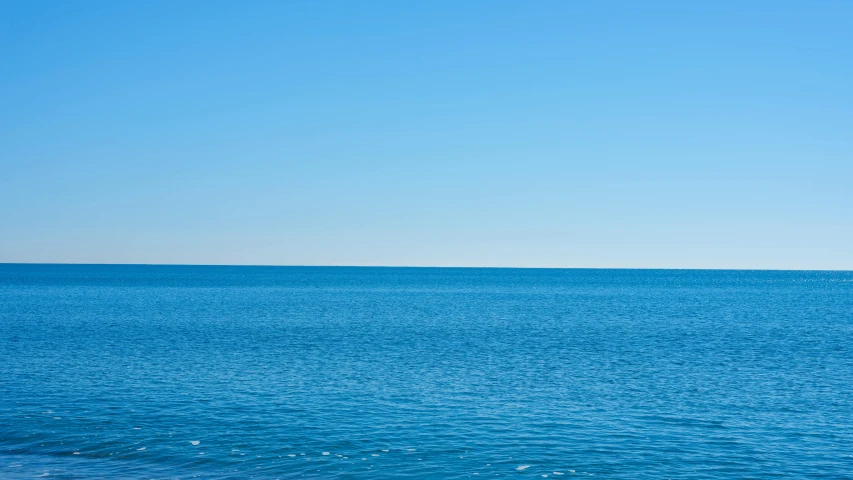 a large body of water with a boat in the distance, minimalism, bright blue sky, gazing off into the horizon, like a catalog photograph, polarizer