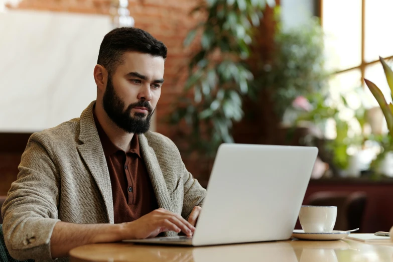 a man sitting at a table using a laptop computer, trending on pexels, renaissance, aboriginal australian hipster, professional profile picture, brown, well - dressed