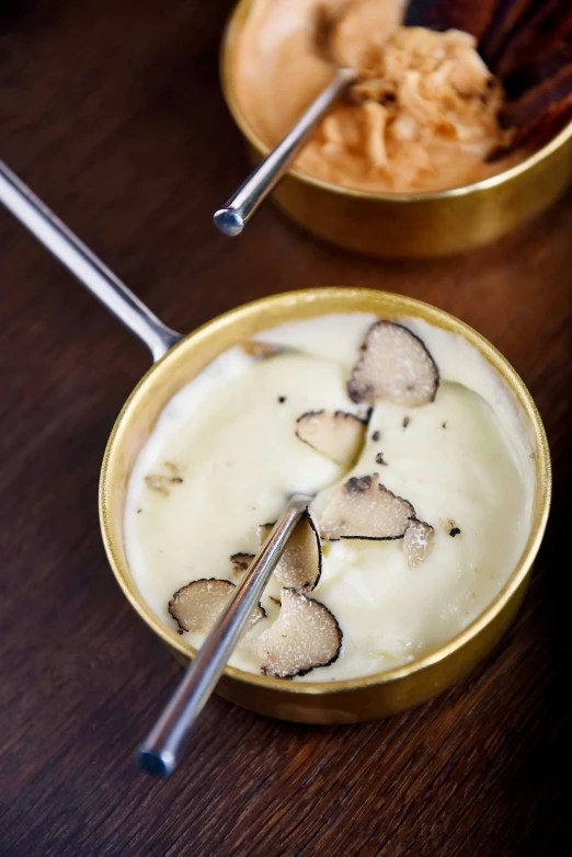 a bowl of soup sitting on top of a wooden table, inspired by Mathieu Le Nain, ice cream, silver，ivory, mayonnaise, amanita