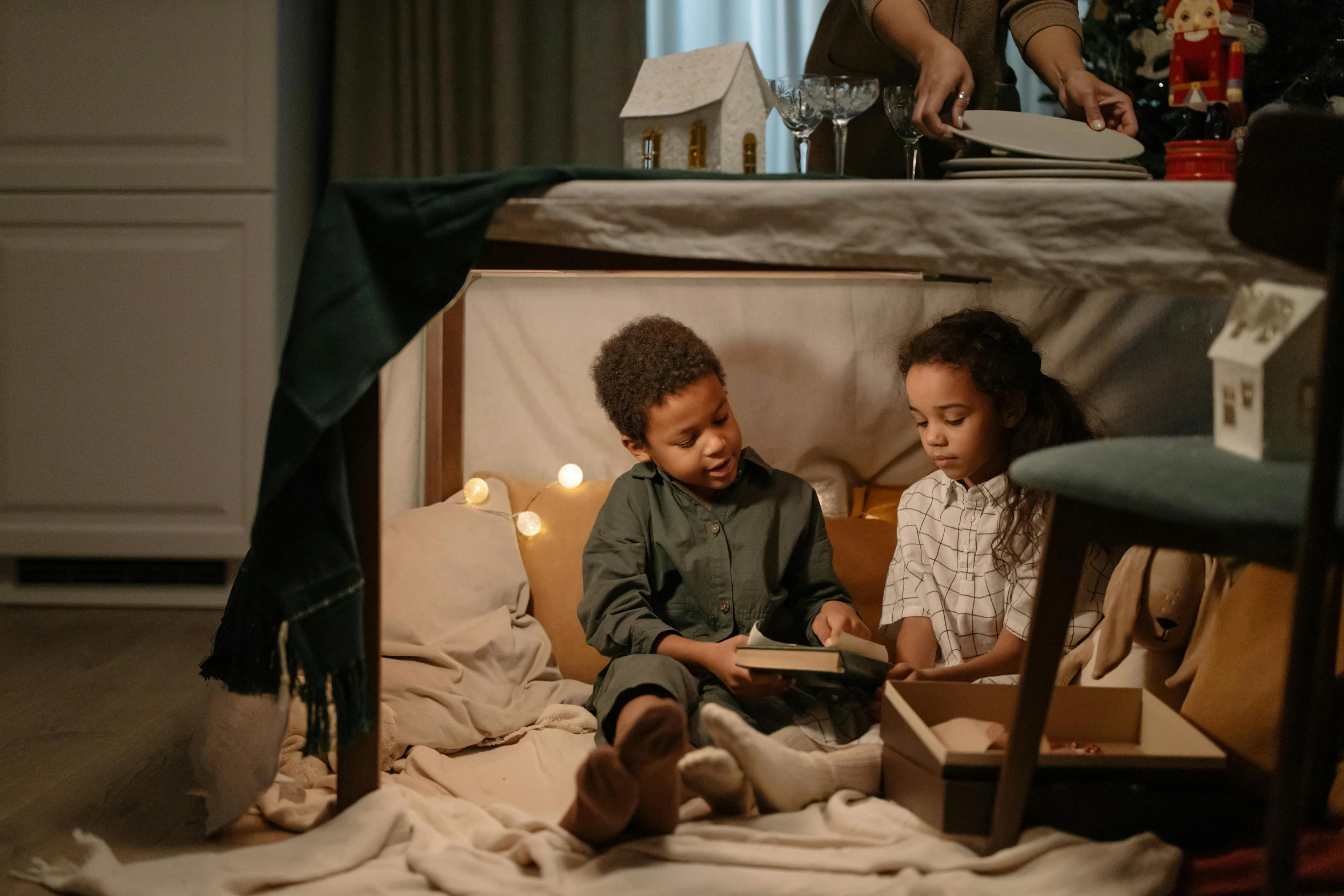 a couple of kids sitting on top of a bed, by Adam Marczyński, pexels contest winner, arts and crafts movement, books cave, tabletop role playing game, ( ( dark skin ) ), family dinner