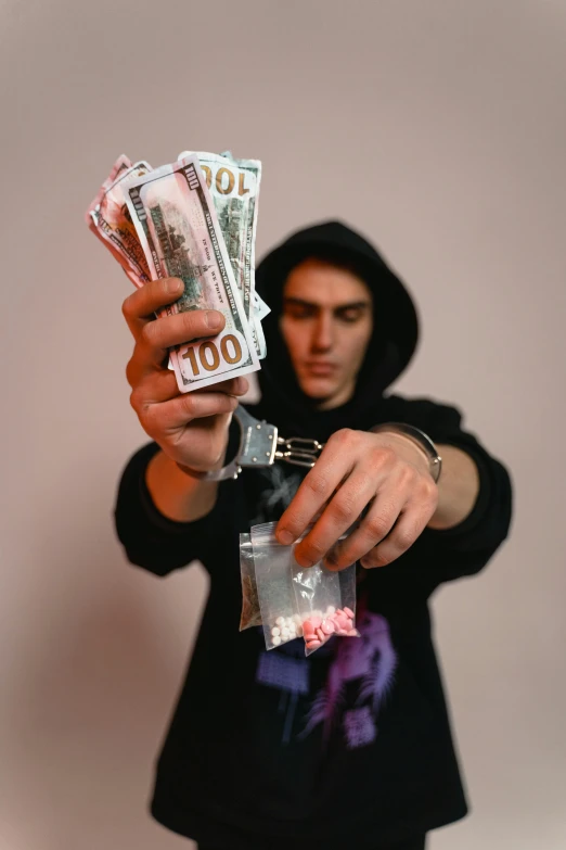 a man holding a bunch of money in his hand, an album cover, by artist, pexels contest winner, drugs, hasan piker, bank robbery, julia hetta