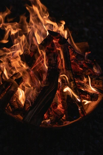 a close up of a fire in the dark, outdoor campfire pit, wearing tumultus flames, vivid ember colors, bark