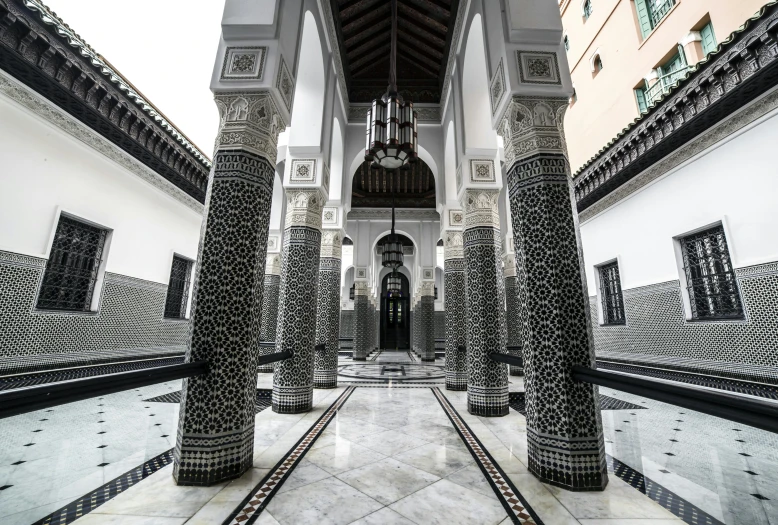 a black and white photo of the inside of a building, inspired by Riad Beyrouti, unsplash contest winner, arabesque, marble floors, tall columns, colorful tiled architecture, 2 5 6 x 2 5 6 pixels