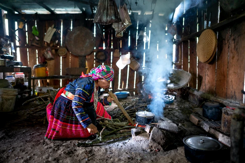 a woman cooking food on a stove in a hut, pexels contest winner, process art, wearing authentic attire, mai anh tran, 💣 💥, getty images proshot