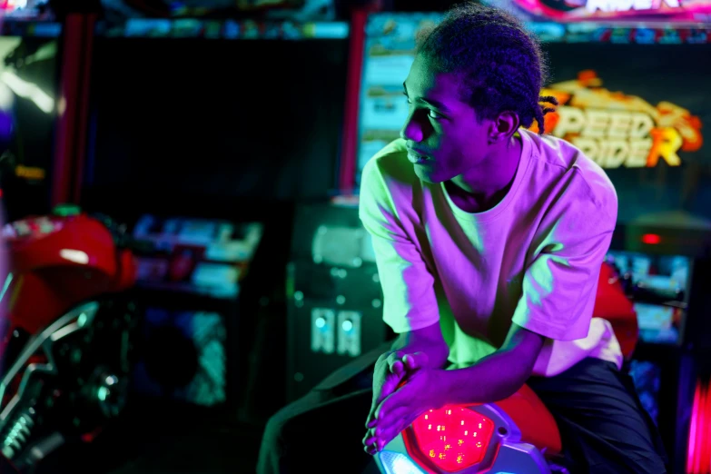 a man sitting on top of a red motorcycle, by Nathalie Rattner, trending on unsplash, arcade cabinet in background, vibrant lights, black teenage boy, bladee from drain gang