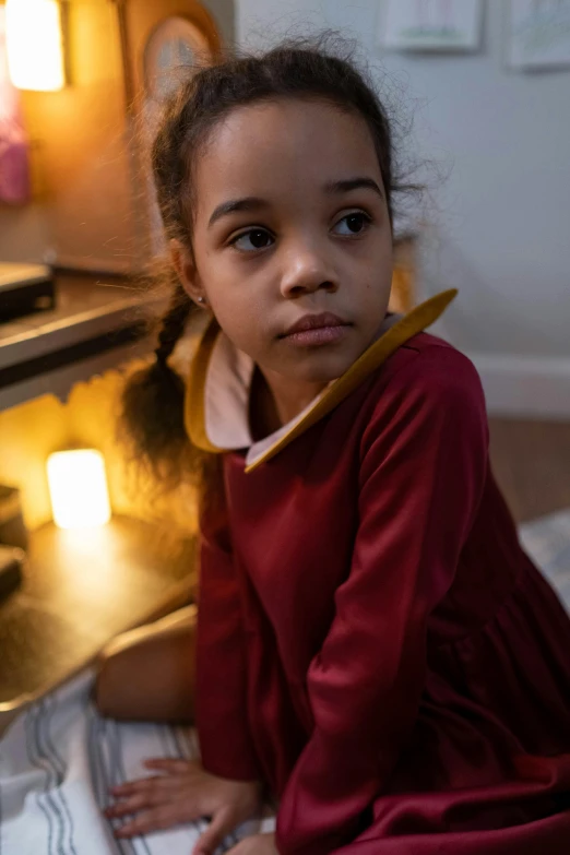 a little girl sitting in front of a stove, inspired by Violet Fuller, pexels, cozy candlelight, girl wears a red dress, school uniform, light skinned african young girl