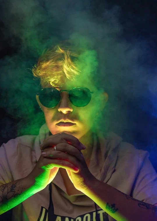 a man with green smoke coming out of his hands, an album cover, unsplash, holography, wearing gold glasses, mr beast, bisexual lighting, like bebop