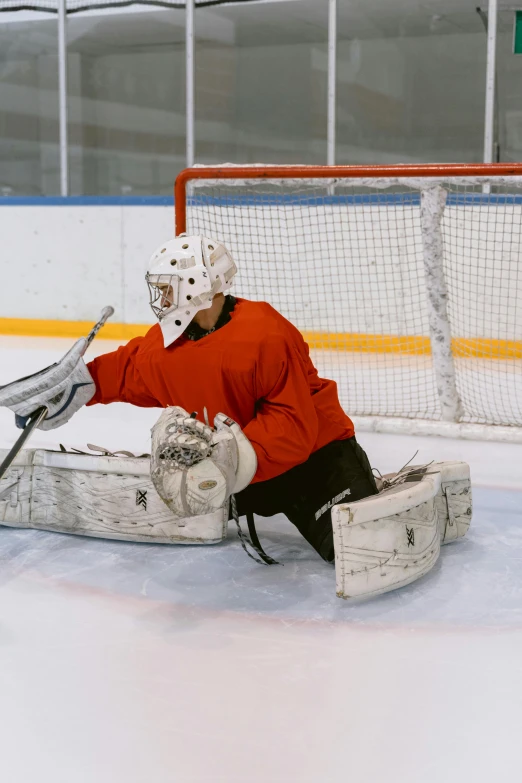 a man playing a game of hockey on an ice rink, full ice hockey goalie gear, getty images, in a chill position, grey