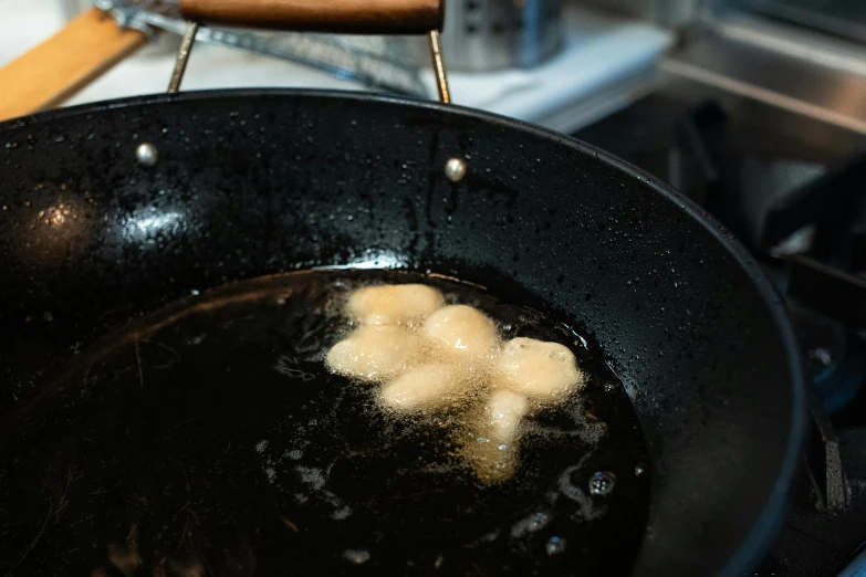 a frying pan sitting on top of a stove, puffballs, oozing black goo, pictured from the shoulders up, lion's mane