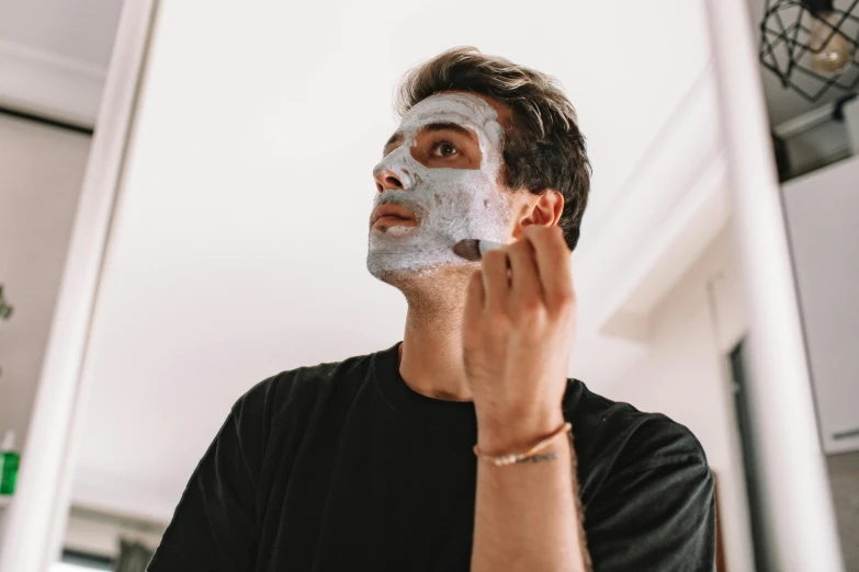 a man shaving his face with a facial mask, by Julia Pishtar, trending on pexels, square facial structure, wearing a grey robe, freckled face, profile image
