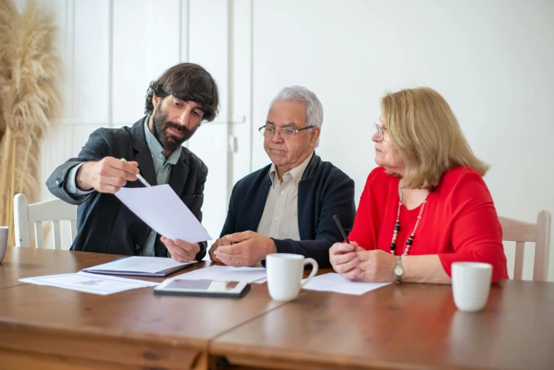 a group of people sitting around a wooden table, document photo, professional image, thumbnail