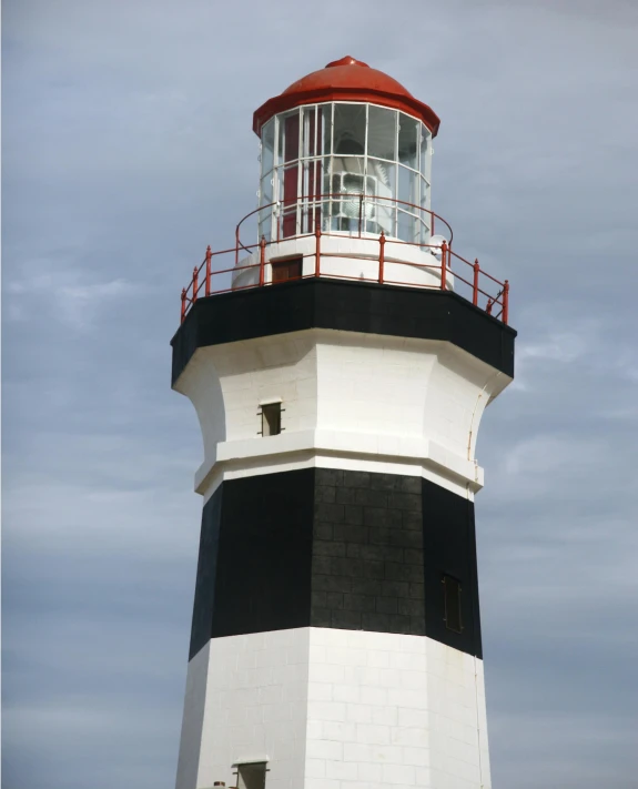 a black and white lighthouse with a red top, by Lorraine Fox, front lighting, high - angle view, looking partly to the left, hight decorated