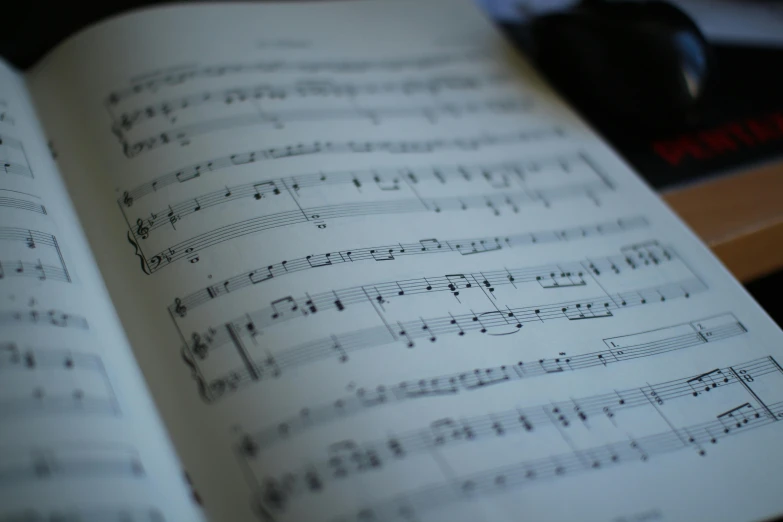 an open book sitting on top of a desk, an album cover, pexels, music notes, sheet music, close up shot, thumbnail