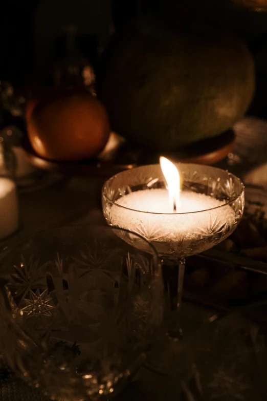 a lit candle sitting on top of a glass table, laura watson, winter, david kassan, vintage vibe