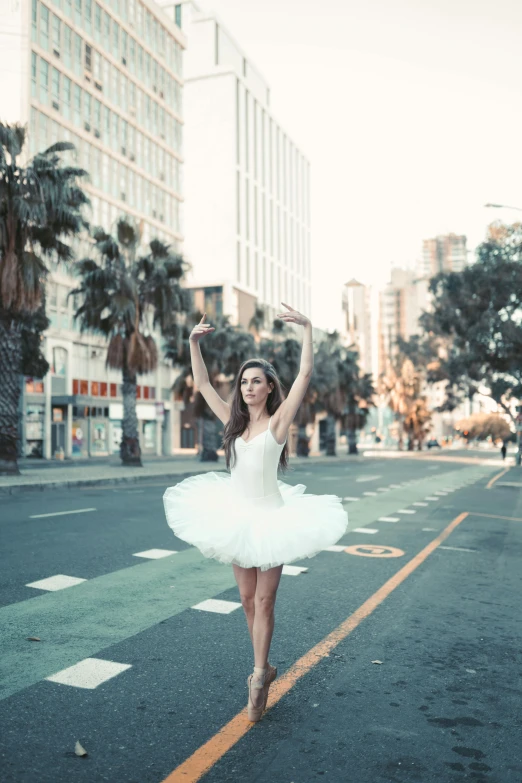 a woman in a white dress is dancing on the street, inspired by Elizabeth Polunin, pexels contest winner, square, 15081959 21121991 01012000 4k, wearing a tutu, !dream los angeles