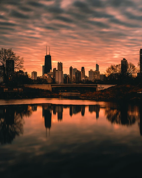 a large body of water with a city in the background, a photo, by Jacob Burck, pexels contest winner, from wheaton illinois, lgbtq, background image, large twin sunset