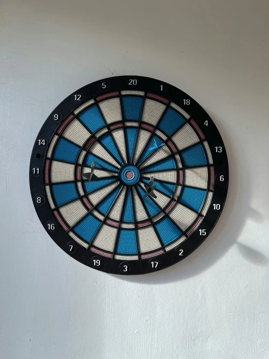 a close up of a dart board on a wall, a portrait, by Tom Wänerstrand, natural soft rim light, blue rim light, multi - coloured, traditional medium