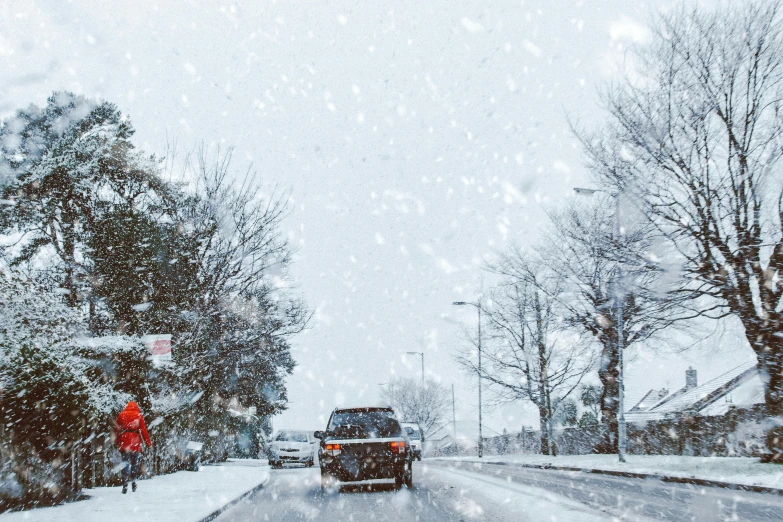 a car driving down a snow covered street, pexels contest winner, cars and people, background image, walking through a suburb, snowflakes
