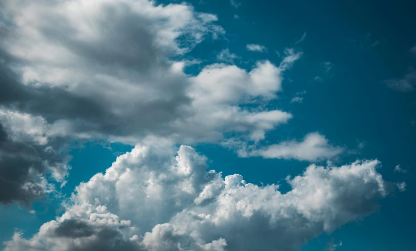 a man flying a kite on top of a lush green field, by Jan Rustem, unsplash, minimalism, giant cumulonimbus cloud, light blues, looking up onto the sky, close - up photograph